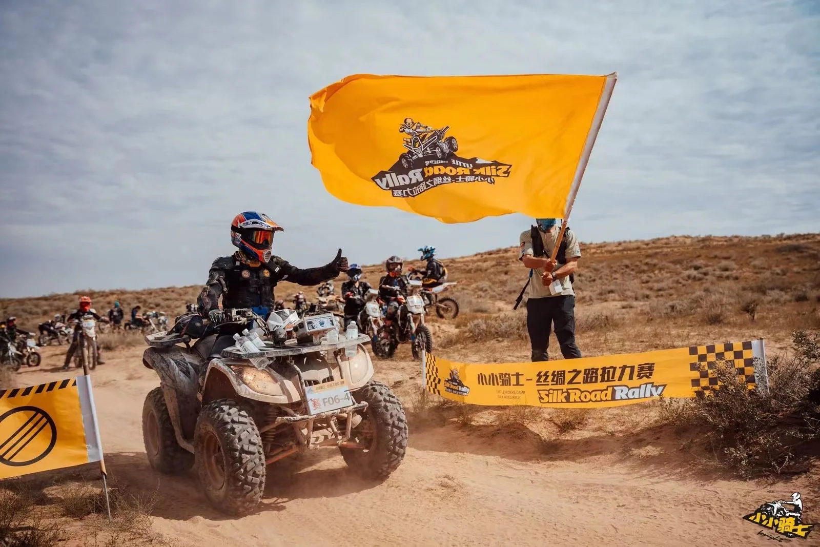 A young ATV rider passes the Silk Road Rally flag gate while teammates wait behind